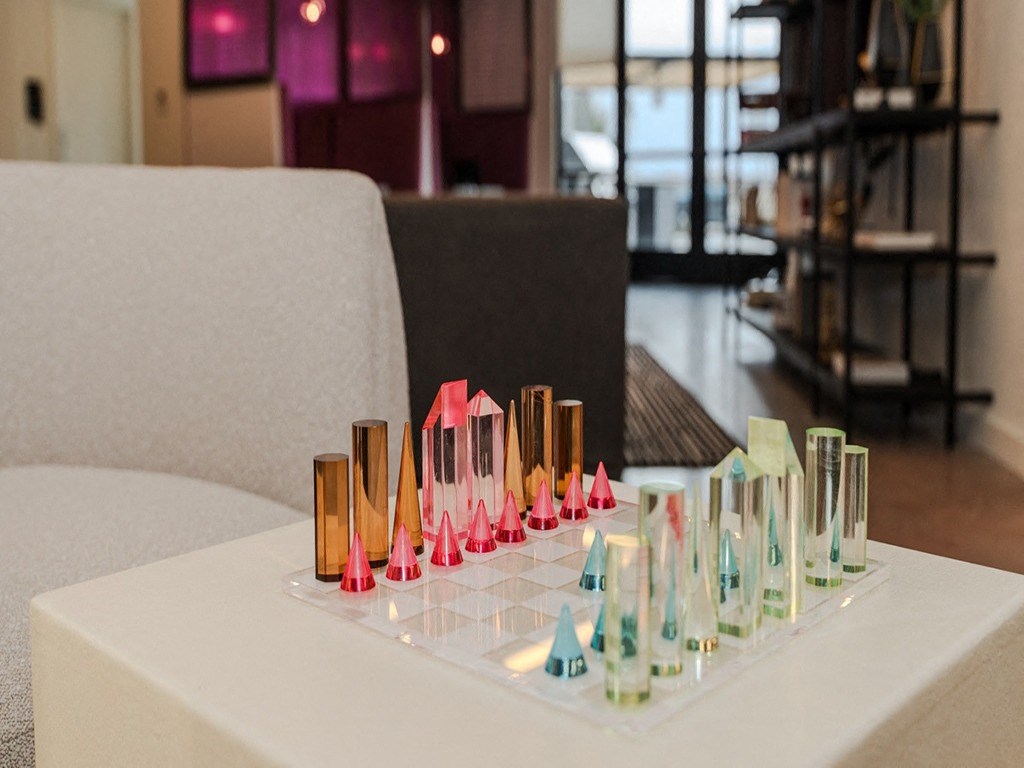 a white table with a tray of colored candles on it